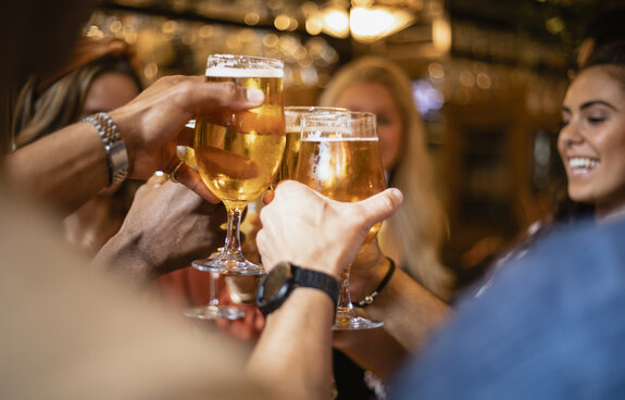 A group of friends having a celebratory toast together at a bar. 1198050518